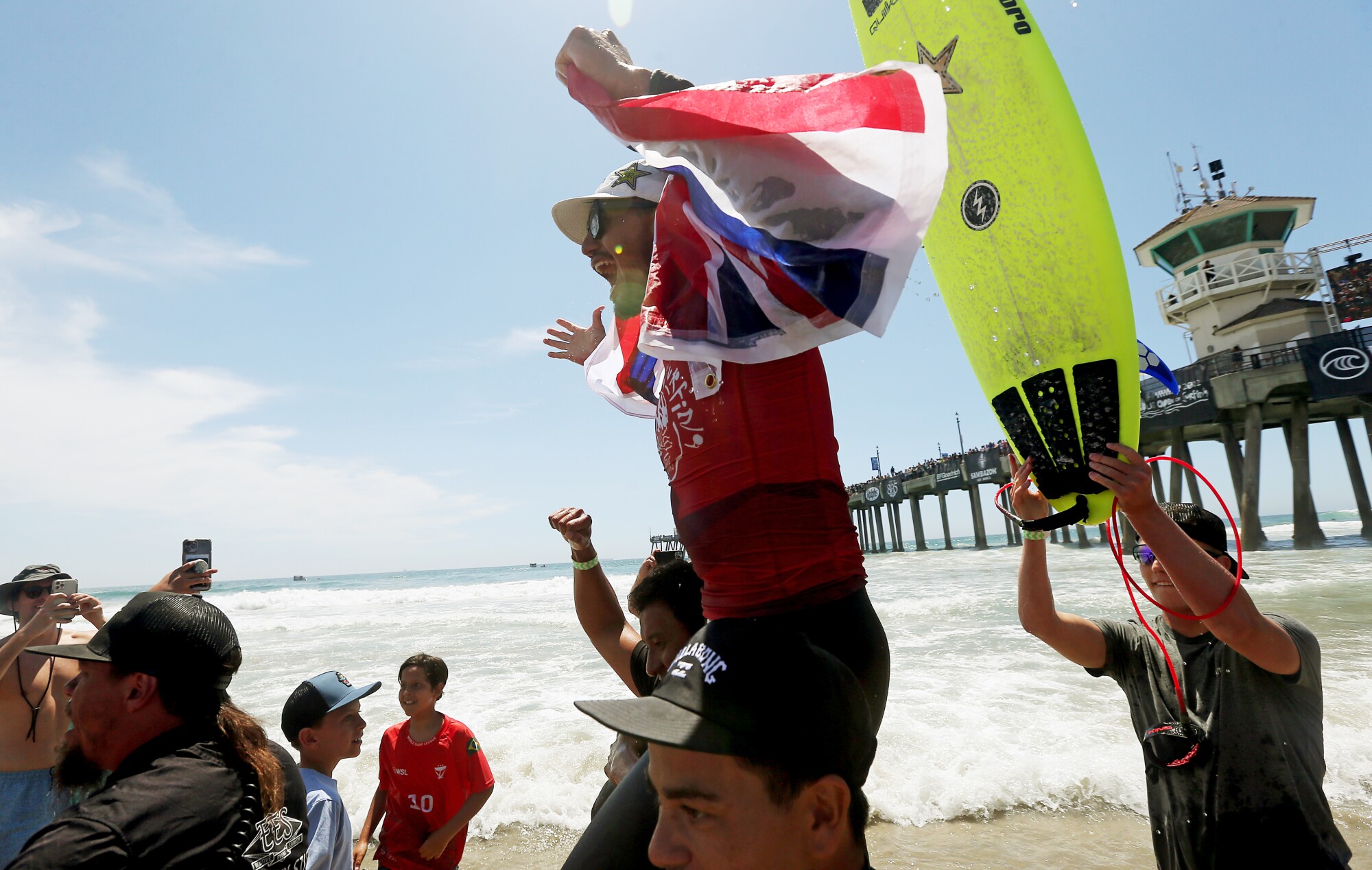 Ezekial Lau is hoisted up by supporters after winning the U.S. Open of Surfing men's championship on Sunday.