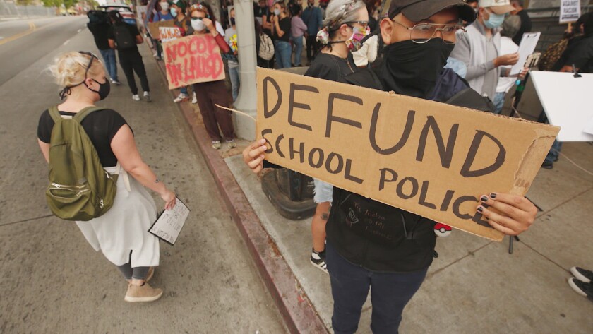A protester pushes for an end to police officers on school campuses.