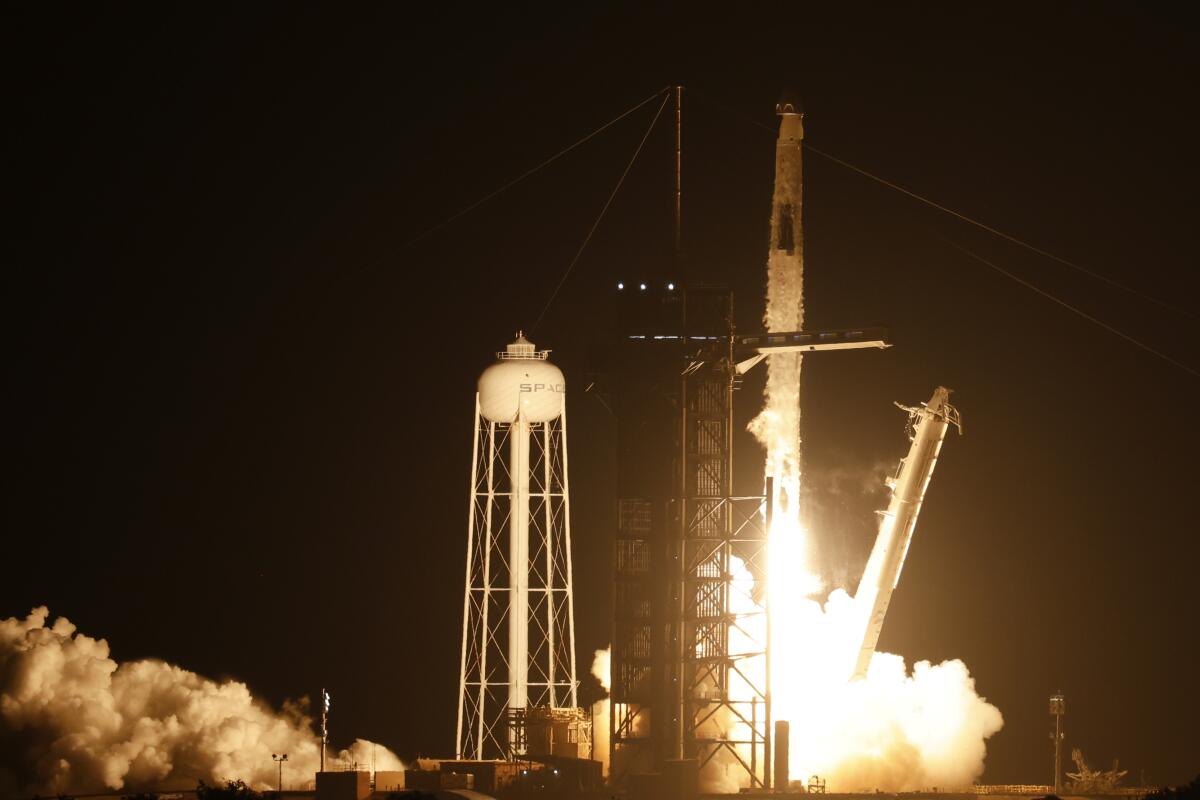 A rocket lifts off from a platform at night