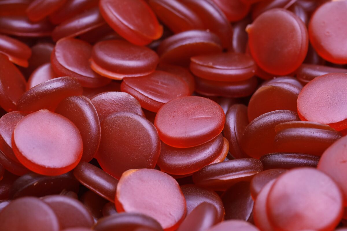 Entire frame filled with red, round marijuana gummies.