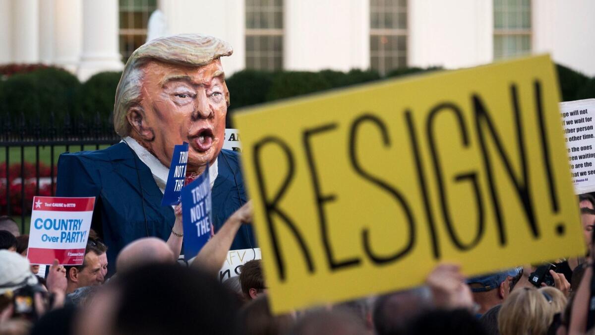 Protesters in front of the White House on July 18 hold signs and a large puppet depicting Donald Trump in a demonstration against the president's actions on Russia.