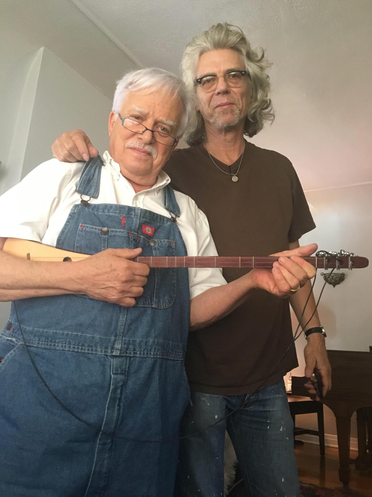 Van Dyke Parks, holding a guitar, poses with Don Heffington.
