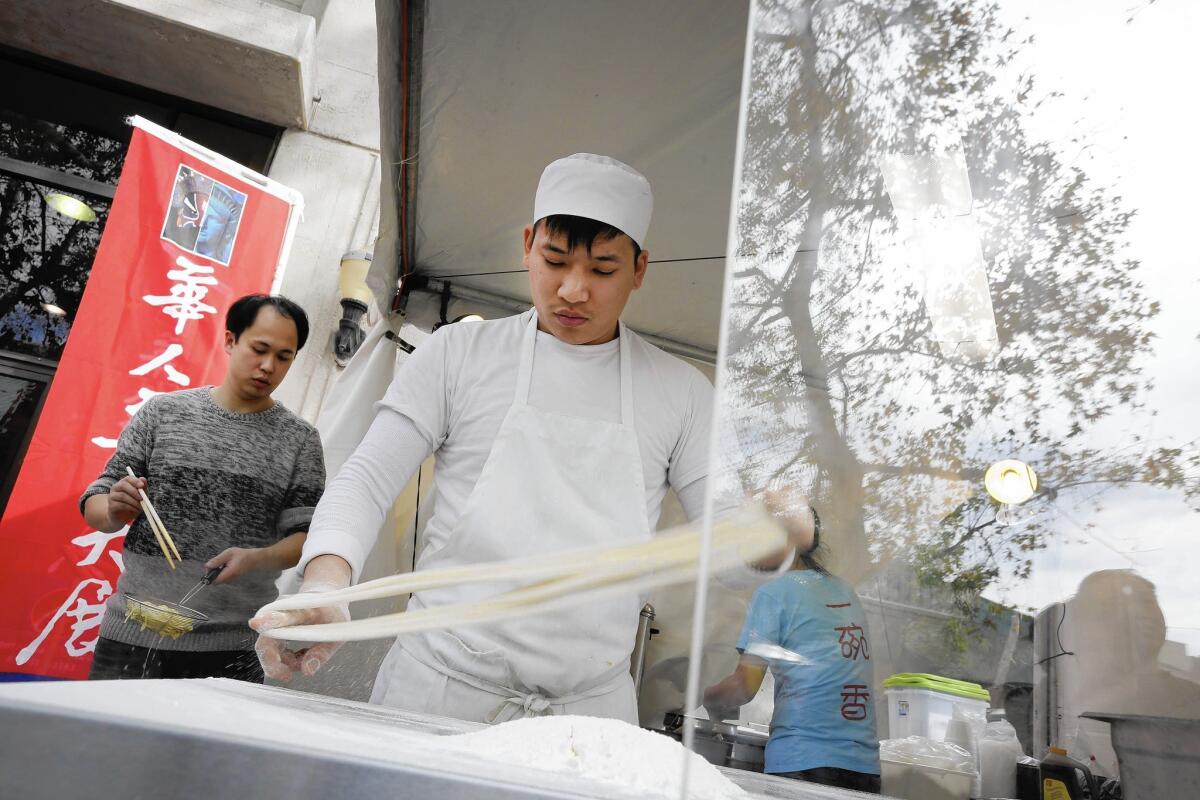 Jason Xu, of the restaurant China Tasty, makes noodles for soup at the Asian American Expo in Pomona.