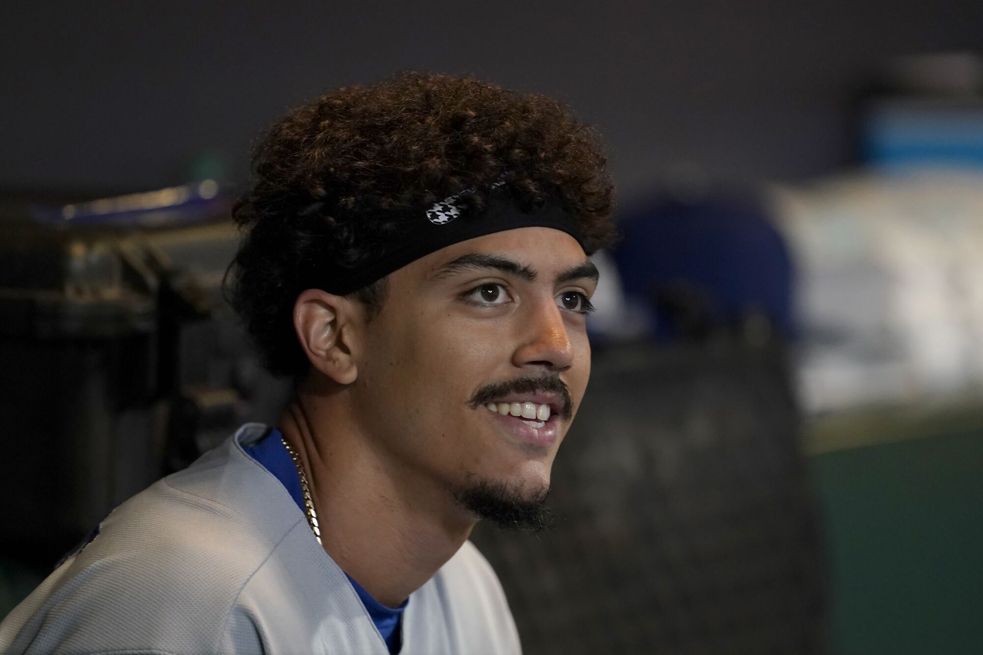 Miguel Vargas sits in the Dodgers dugout during a game.