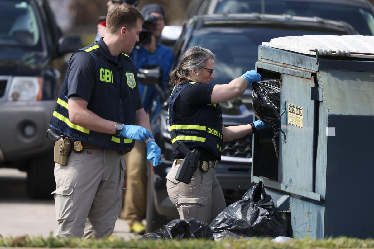 Agentes del Buró de Investigaciones de Georgia registran un contenedor de basura al otro 