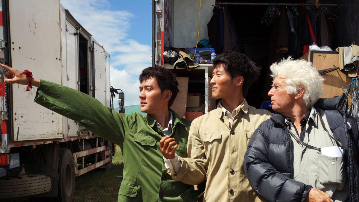 Chinese actors Feng Shaofeng, left, and Shawn Dou, center, are photographed on set of the film "Wolf Totem," = with French film director Jean-Jacques Annaud.