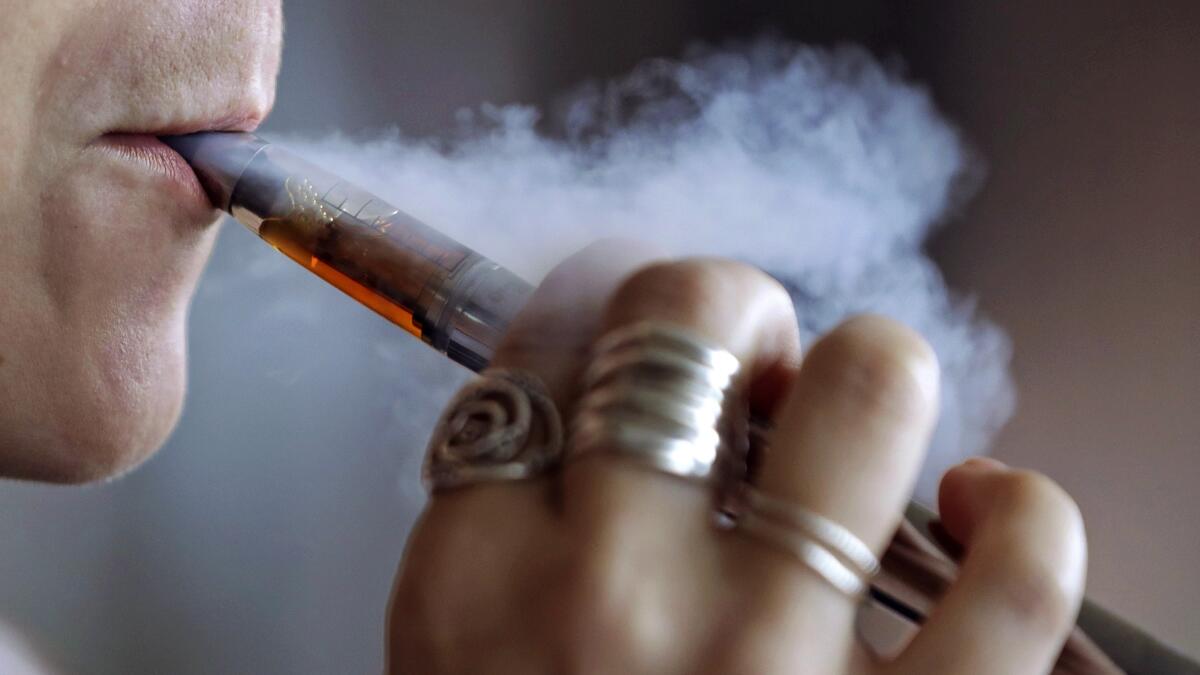 A woman uses an electronic cigarette.