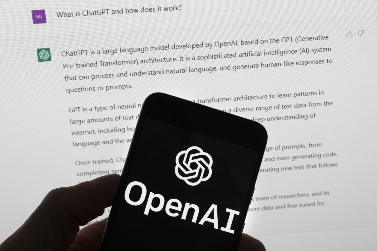 El logotipo de OpenAI se ve en un teléfono móvil frente a la pantalla 