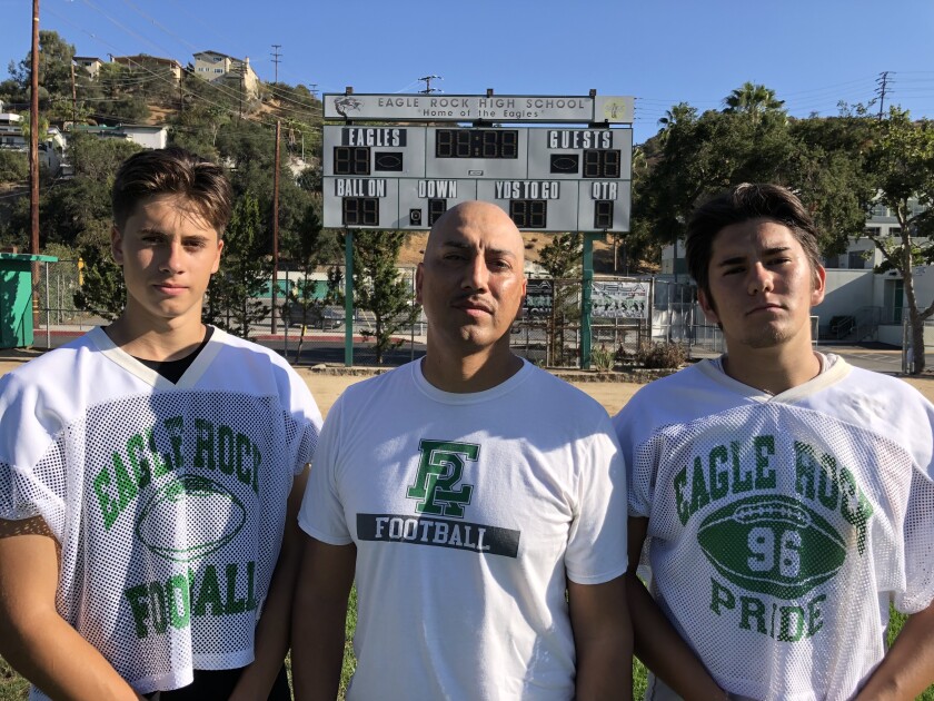 Eagle Rock football players Mycah and Brooklyn Pasten with their father, Mario, an assistant coach.