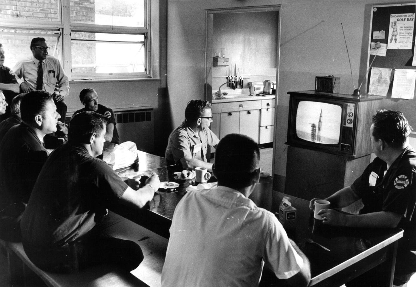 Seated in the kitchen of a Chicago firehouse at 8026 Kedzie Ave., firefighters watch the television as Apollo 11 is launched on July 16, 1969, in Chicago.