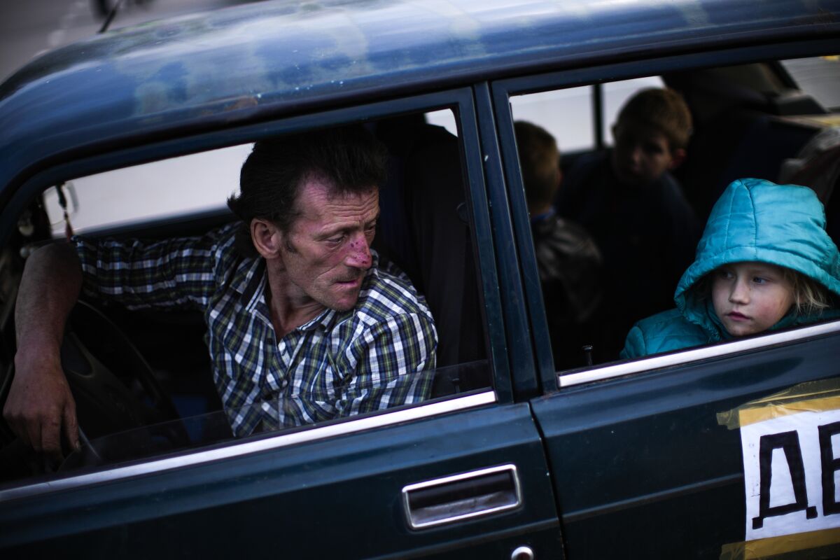 A man looks at his daughter as they arrive to a reception center for displaced people in Zaporizhzhia, Ukraine, Monday, May 2, 2022. Thousands of Ukrainians continue to leave Russian occupied areas. (AP Photo/Francisco Seco)