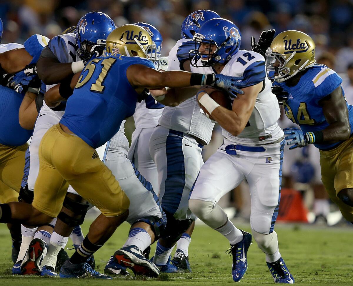 UCLA linebacker Aaron Wallace applies pressure on Memphis quarterback Paxton Lynch during a Sept 6, 2014, game at the Rose Bowl.