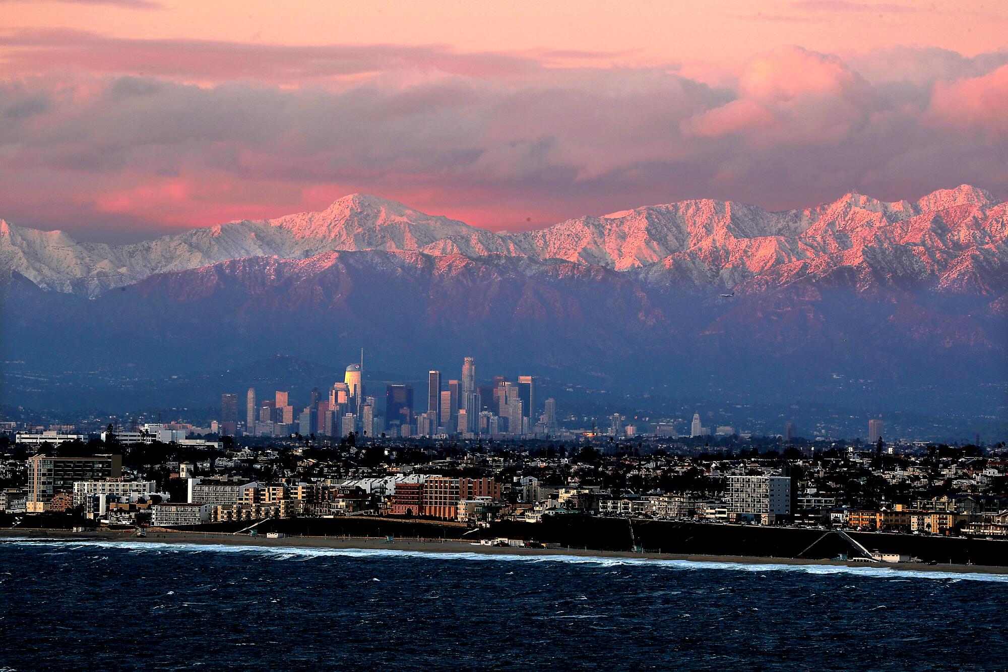 Snow-covered mountains provide a backdrop for the downtown L.A. skyline.