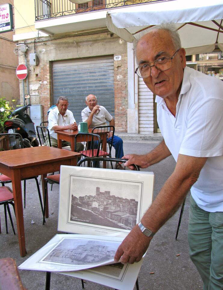 A merchant offers souvenir pictures in the Piazza Liberta in Salemi. Read more: Western Sicily, where centuries and cultures converge