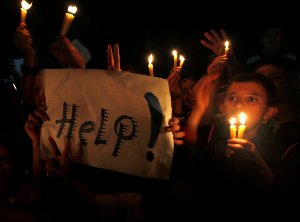 Palestinian children hold candles during a demonstration against severe fuel cuts in Gaza city on Sunday.