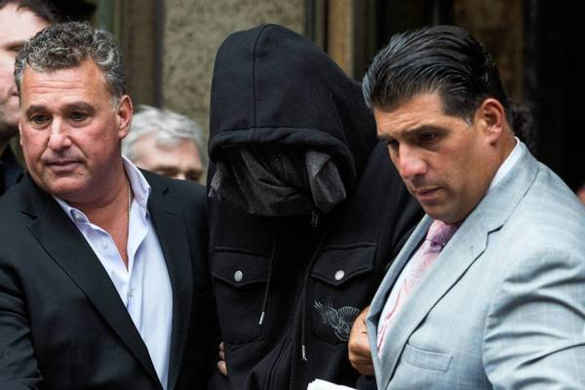 Wojciech Braszczoka, center, with his face obscured, is led from Manhattan Criminal Court on Oct. 9, 2013. Braszczok is charged in connection with an attack on a family SUV.