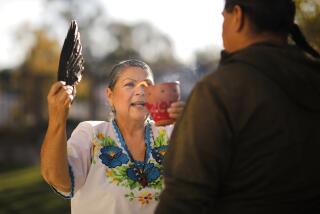 Alpine, CA - November 21: Grace Sesma does a limpia, a spiritual cleansing with client Mario Ceballos during a curanderismo session at her Alpine home on Tuesday, November 22, 2022. Curanderismo is a traditional Mexican American healing system that holistically treats mental, emotional, physical and spiritual illnesses. (K.C. Alfred / The San Diego Union-Tribune)