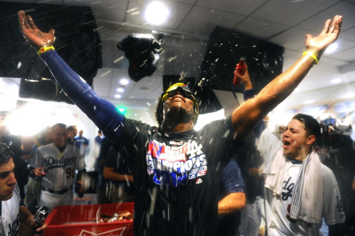 Dodgers center fielder Yasiel Puig celebrates with teammates in the clubhouse after defeating the Giants to win the NL West title.