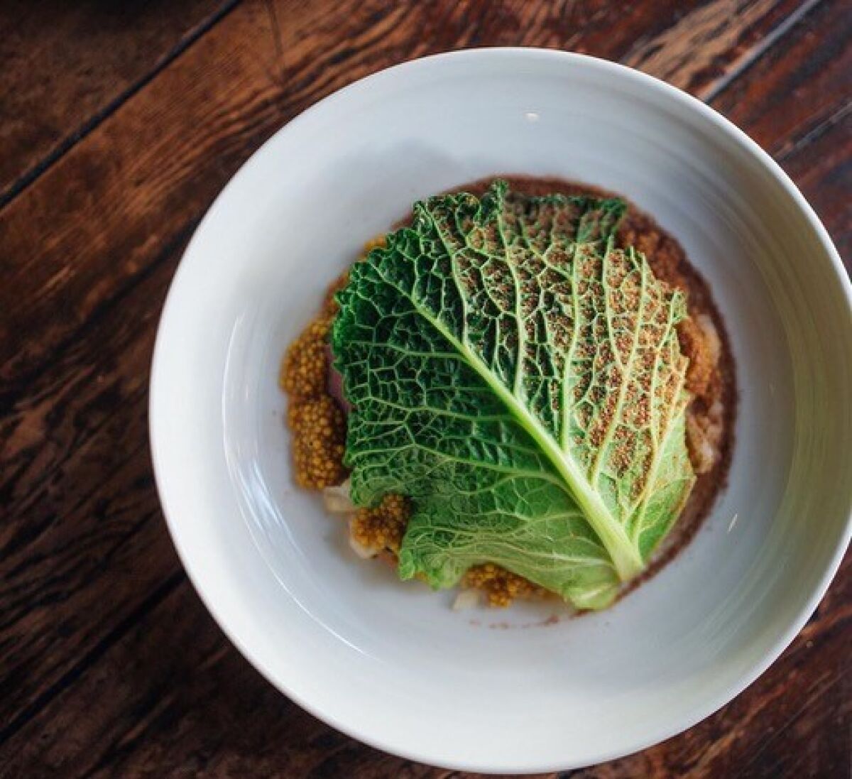 One of co-executive chef Andrew Santana's new dishes at Campfire restaurant in Carlsbad is Lengua, beef tongue pastrami with charred cabbage, roasted Brussels sprouts, sauerkraut, pickled mustard seed and rye.