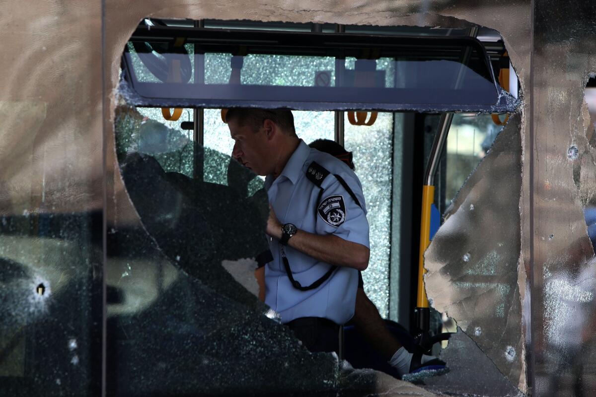 Israeli police inspect a bus after Palestinian shooting attack in the east Jerusalem Jewish settlement of Armon Hanatsiv, killing two Israelis.