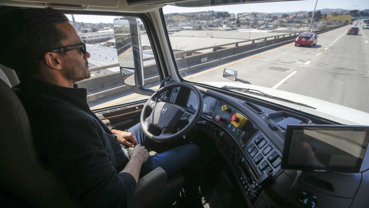 Matt Grigsby, senior program engineer at Otto, takes his hands off the steering wheel of a self-driving big-rig truck during a 2016 demonstration.