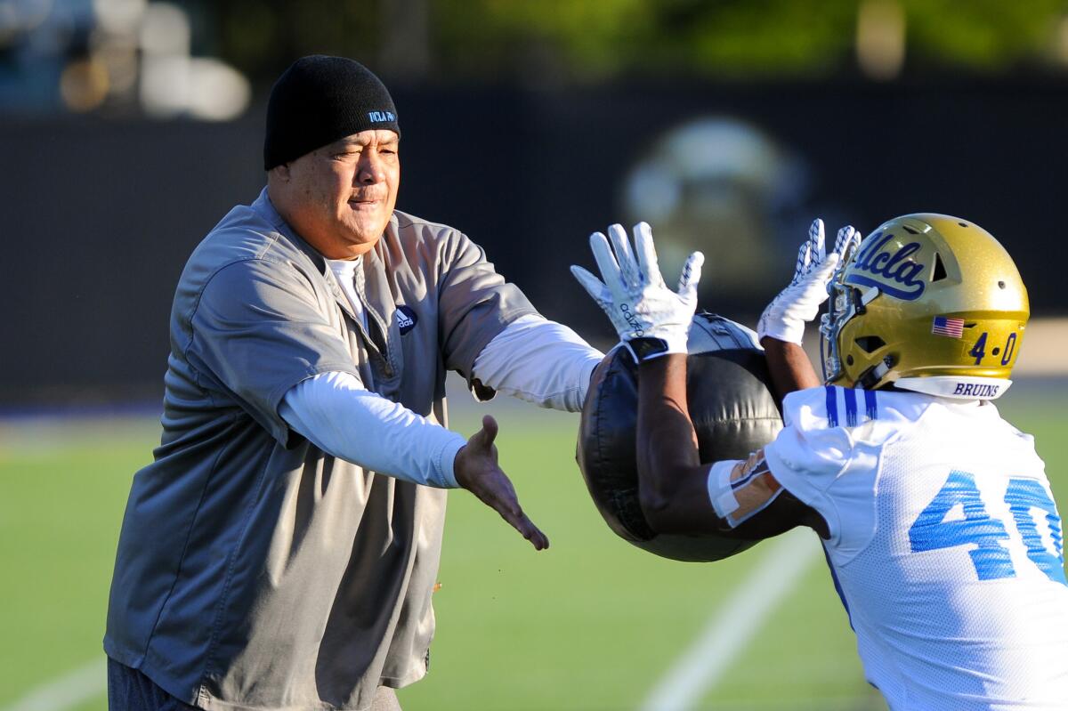 Kennedy Polamalu, shown throwing a medicine ball during the opening day of UCLA football practice last spring, was in his first season as offensive coordinator.