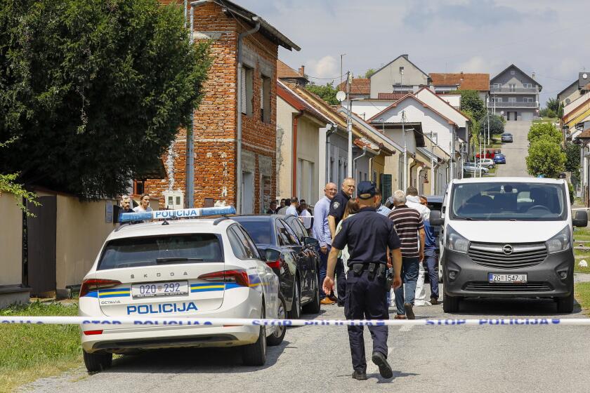 Police and forensics gather near the crime scene in Daruvar, central Croatia, Monday, July 22, 2024. An armed assailant entered a care home for older people in central Croatia Monday and opened fire, killing five people and wounding several others, authorities and media reports said. (Zeljko Puhovski/Cropix via AP)