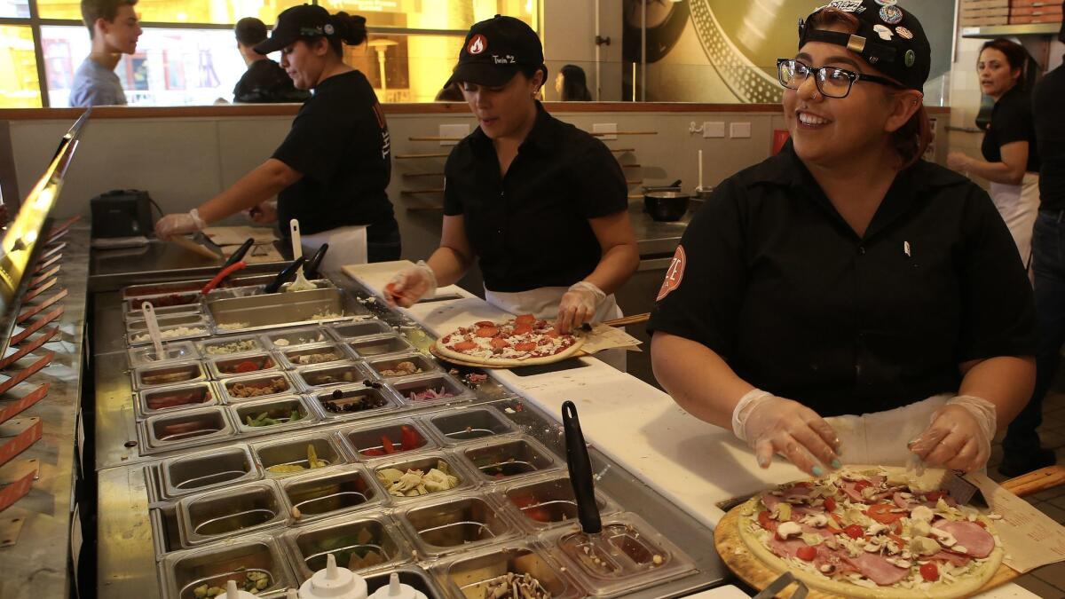 Cooks prepare pies at Blaze Pizza in Pasadena in 2016. Blaze is looking to expand outside North America.