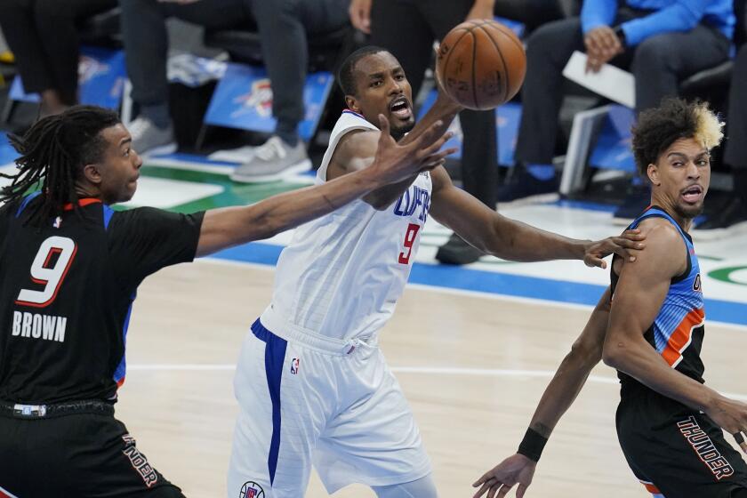 Clippers center Serge Ibaka reaches for a rebound between Thunder center Moses Brown and forward Charlie Brown Jr.