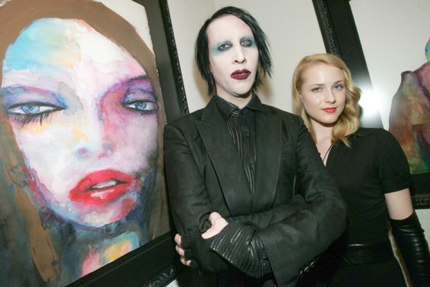 Marilyn Manson and Evan Rachel Wood stand near a painting