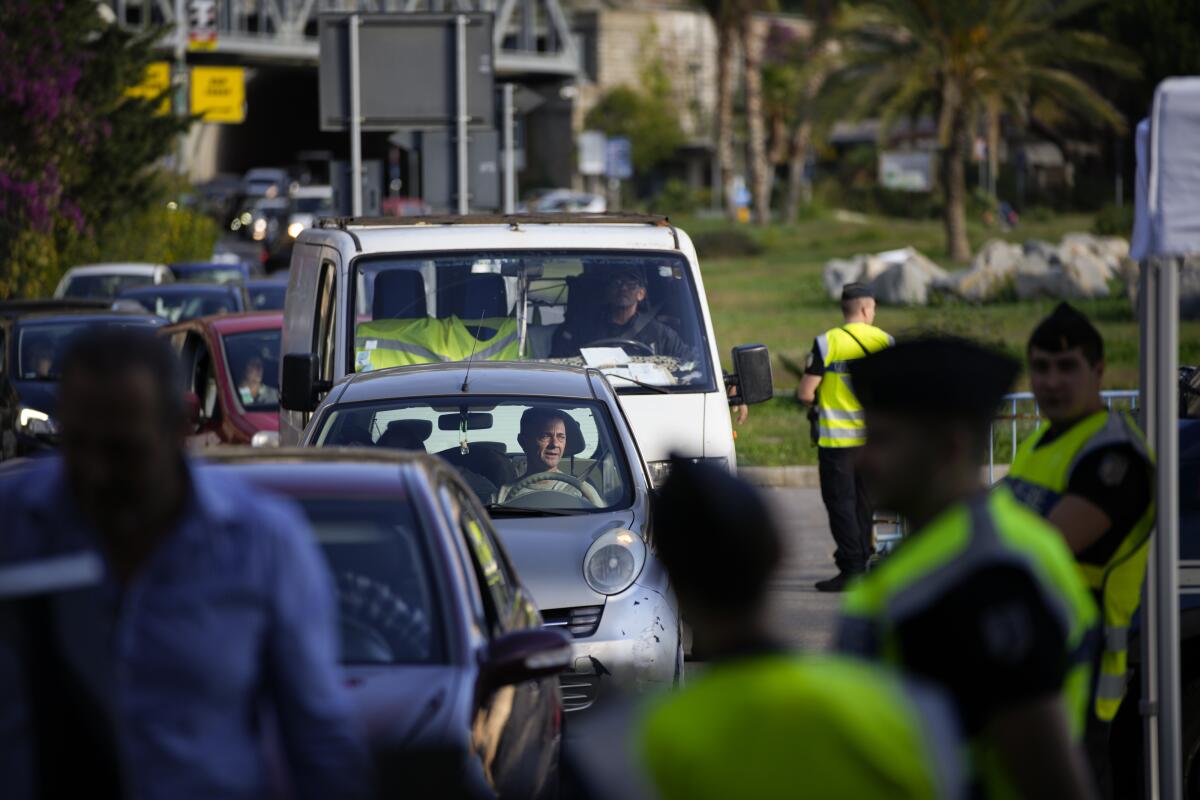 Cars line up for police checks before entering France from Italy at a border crossing in Menton, southern France, Sunday, Nov. 13, 2022. Lines formed Sunday at one of Italy’s northern border crossings with France following Paris’ decision to reinforce border controls over a diplomatic row with Italy about migration policy and humanitarian rescue ships that shows no end in sight. (AP Photo/Daniel Cole)