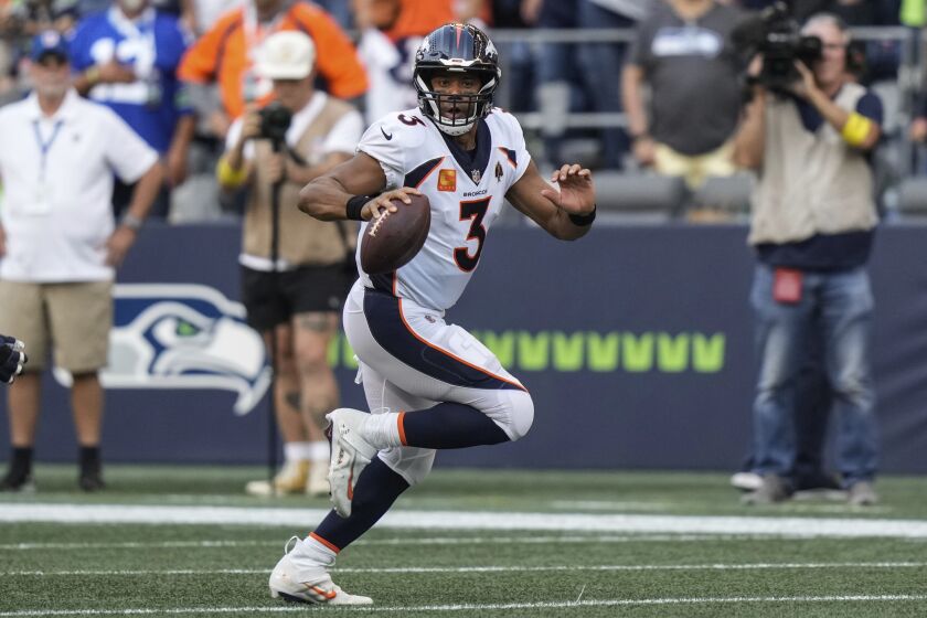 Denver Broncos quarterback Russell Wilson rolls out of the pocket during an NFL football game against the Seattle Seahawks, Monday, Sept. 12, 2022, in Seattle. The Seahawks won 17-16. (AP Photo/Stephen Brashear)