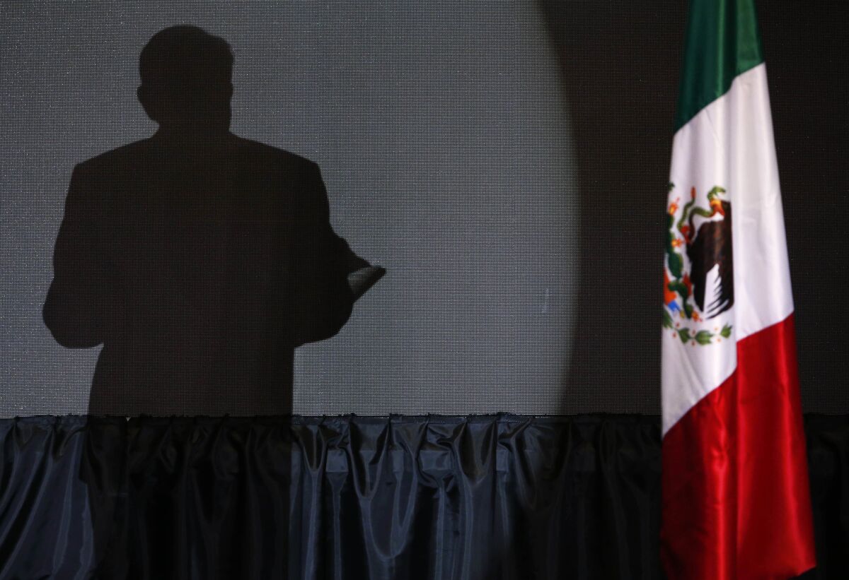 ARCHIVO - La sombra del candidato presidencial Andrs Manuel Lpez Obrador se proyecta en una pantalla mientras da su primer discurso de victoria en la sede de su campaa en el hotel Hilton en Ciudad de Mxico, a fines del 1 de julio de 2018. (Foto AP/Marco Ugarte, Archivo)