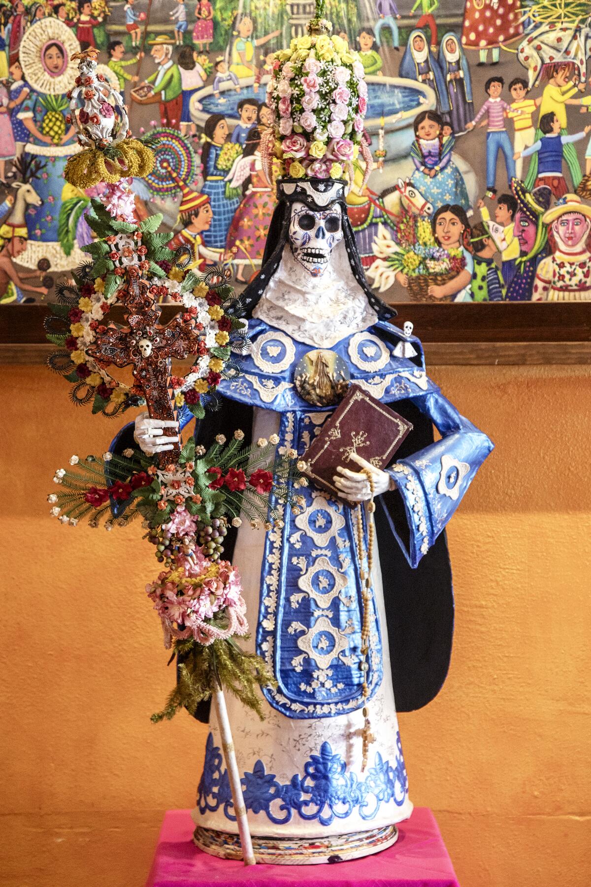 A holy figure with an elaborately decorated cross and Bible.
