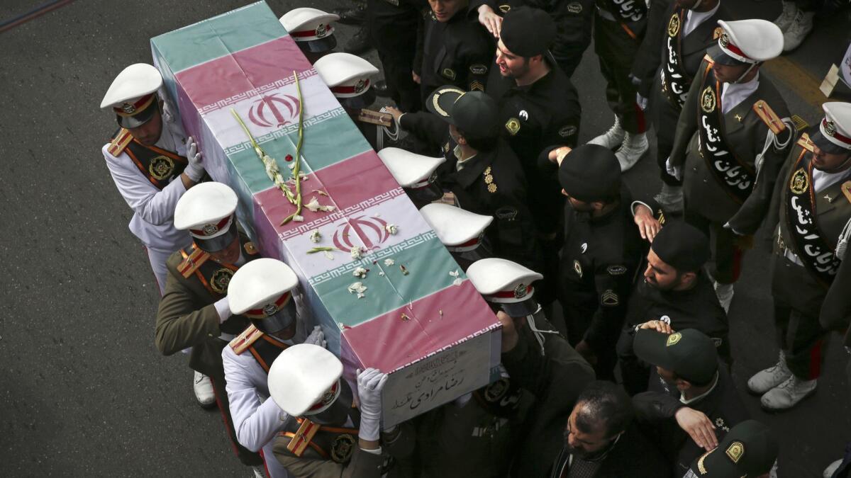 Iranian policemen carry a flag-draped coffin of their colleague, one of three killed when a bus rammed into a group of police officers at a protest by followers of a Sufi Islamic leader. The funeral took place in Tehran on Feb. 22, 2018.