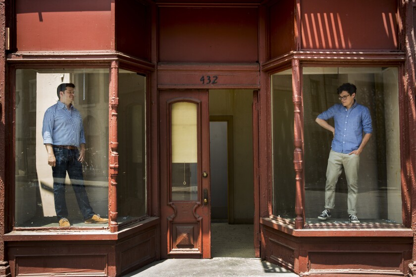 Chris Miller, left, and Phil Lord, directors of the new film "22 Jump Street," are photographed inside a building fascade on "New York Street" on the 20th Century Fox studio lot.