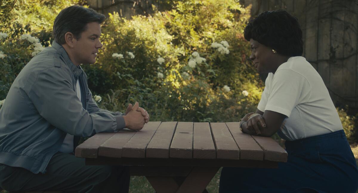 A man sits across a picnic table from a woman as they talk in a scene from "Air."
