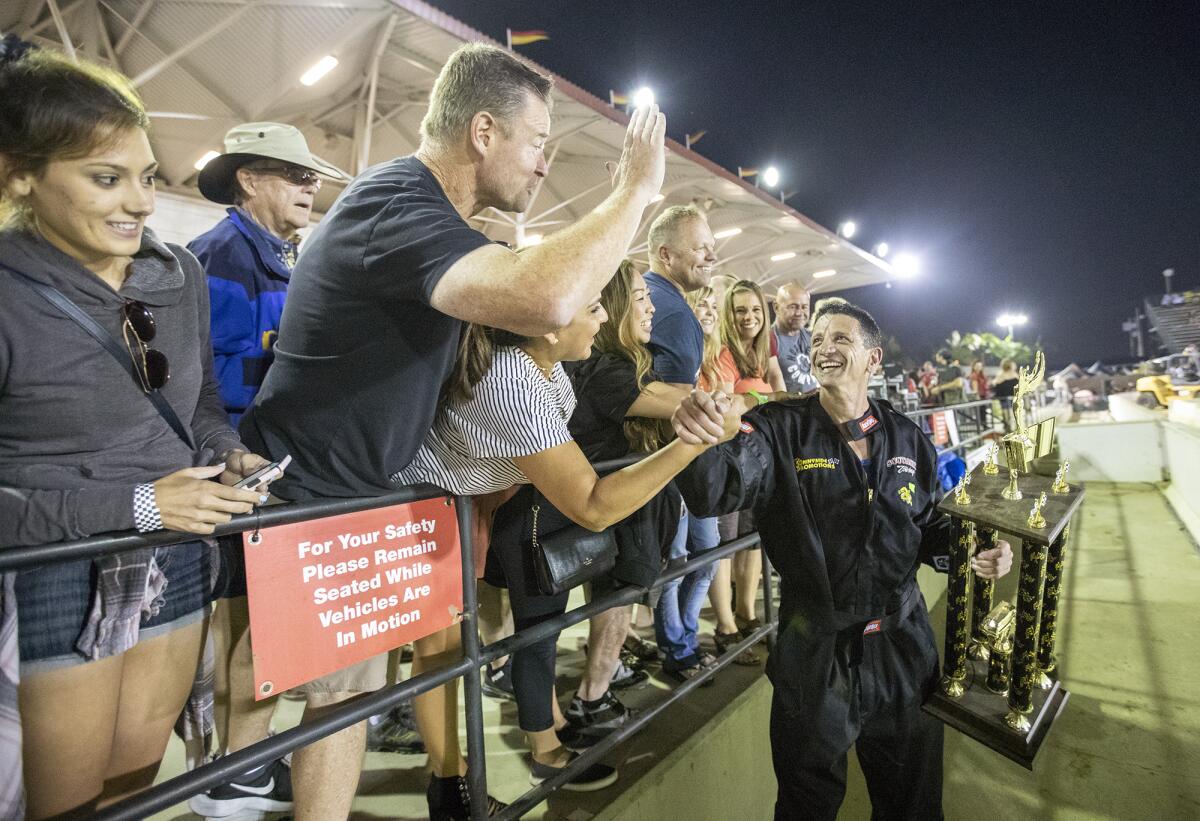 Tustin Police Chief Stu Greenberg is congratulated by fans after winning Friday night's Motorhome Madness demolition derby pitting area police and fire chiefs at the Orange County Fair in Costa Mesa.