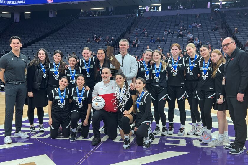 The Shalhevet girls basketball team celebrates after winning a state championship.