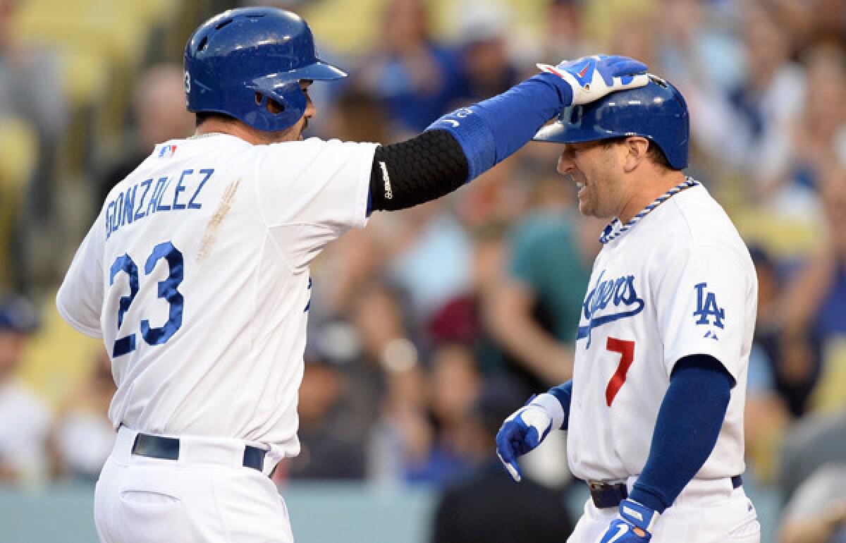 Dodgers utility player Nick Punto (7) get a pat on the head from first baseman Adrian Gonzalez, who hit a three-run home run against against the Miami Marlins earlier this month.