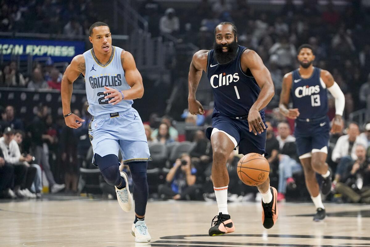 Clippers guard James Harden (1) dribbles up court on a fast break ahead of Grizzlies guard Desmond Bane.