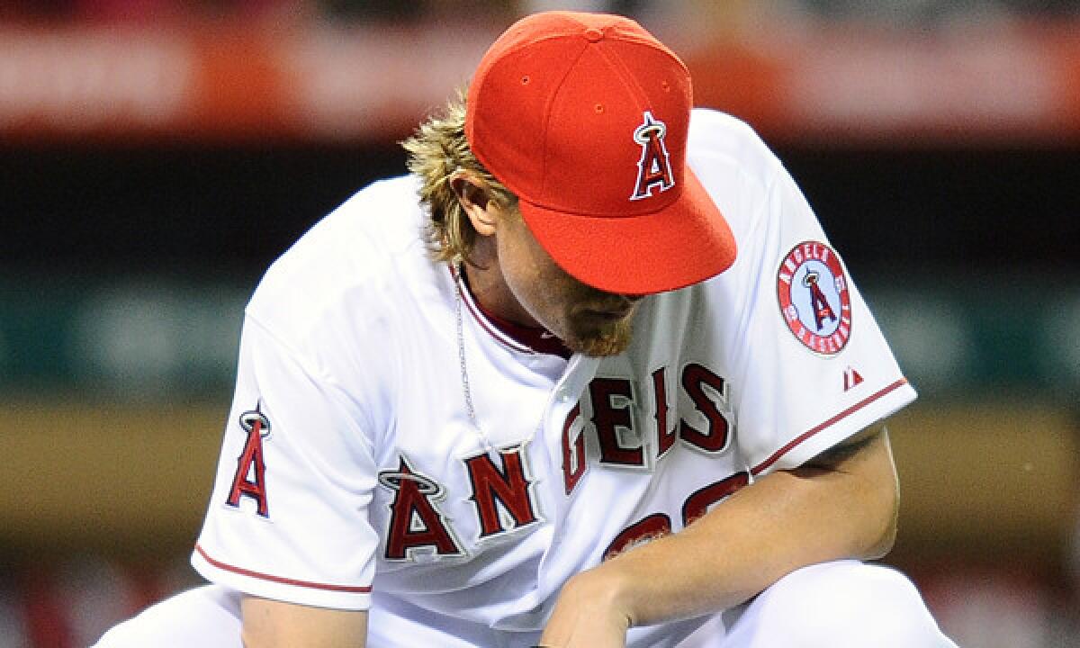 Angels starting pitcher Jered Weaver reacts after giving up a base hit during the team's 10-3 season-opening loss to the Seattle Mariners at Angel Stadium on Monday.