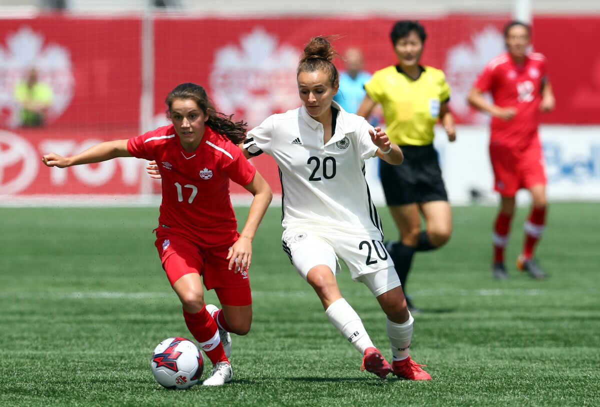 Canada's Jessie Fleming, left, controls the ball ahead of Germany's Lina Magull during an international friendly match in June 2018.
