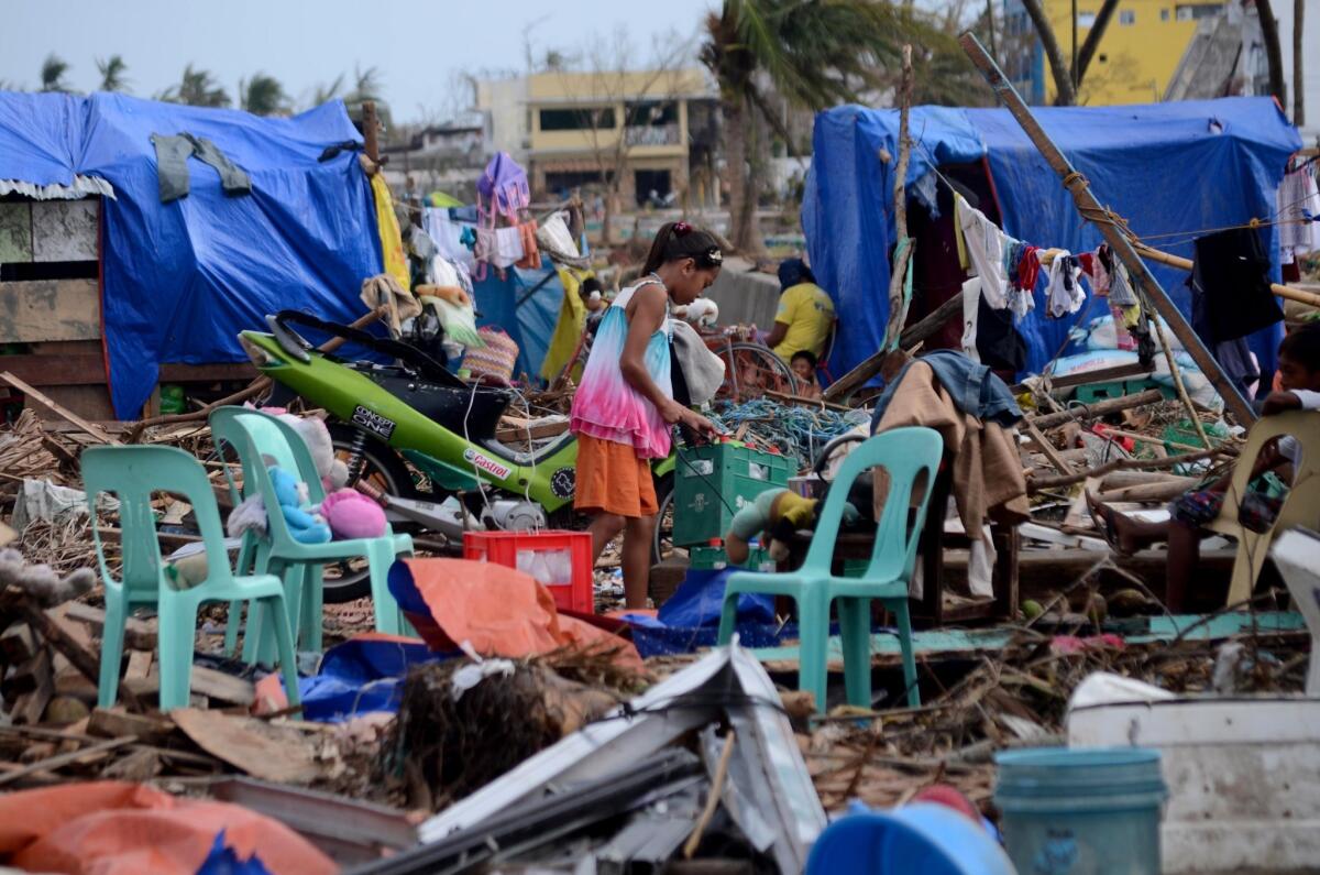 A girl rummages through debris in an area devastated by Typhoon Haiyan in the Philippines.