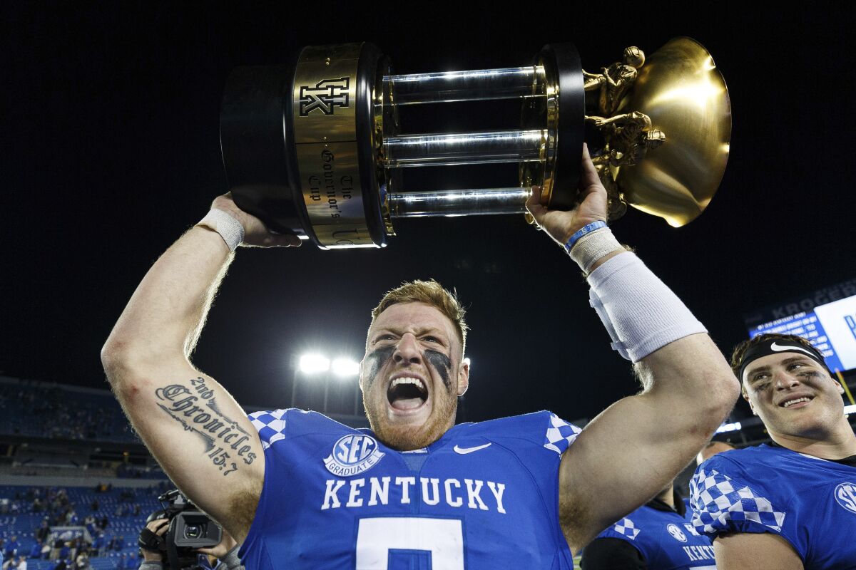 Kentucky quarterback Will Levis holds up the Governor's Cup trophy after Kentucky defeated Louisville in an NCAA college football game in Lexington, Ky., Saturday, Nov. 26, 2022. (AP Photo/Michael Clubb)