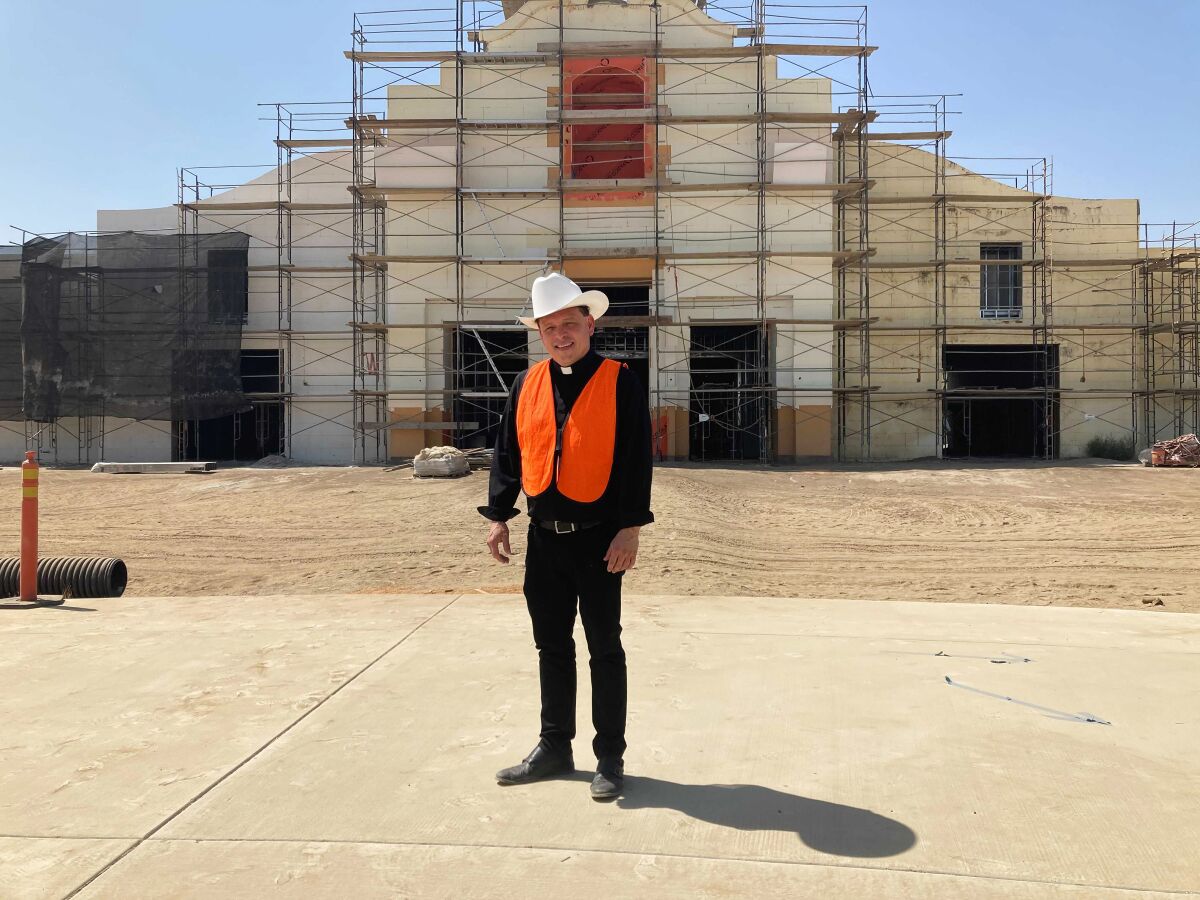 The Rev. Alex Chavez poses in front of the St. Charles Borromeo Catholic Church construction site in Visalia, Calif., on Thursday, Aug. 26, 2021. Chavez says the large-scale parish — which has been years in the making — is necessary to address the Catholic population boom in a region where, like much of the world, there is a dire shortage of priests. (Alejandra Molina/RNS via AP)