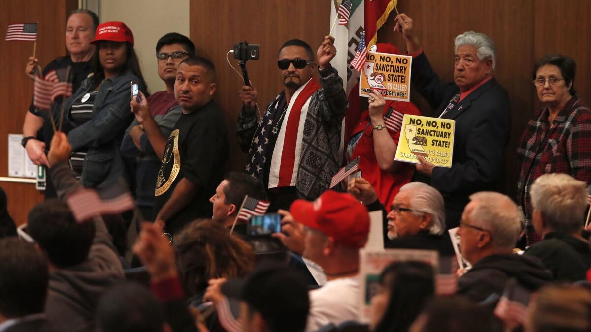 Opponents of Senate Bill 54 line up to speak during the Costa Mesa City Council meeting on Tuesday. The council took an official stand against Senate Bill 54, California’s “sanctuary state” law.