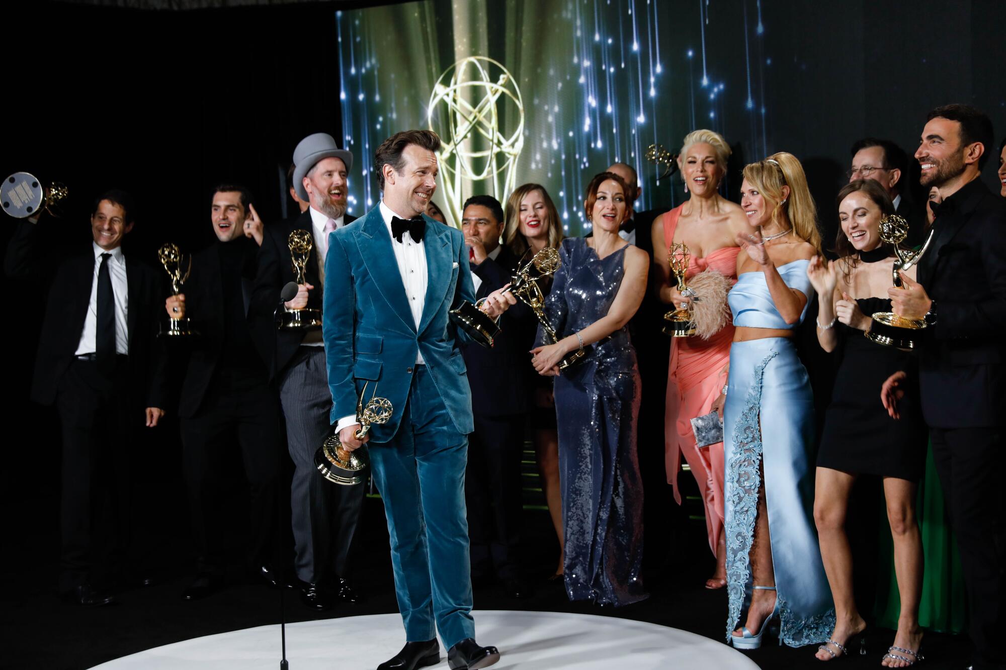 Winners for 'Ted Lasso' pose in formal wear in the press room during the 73rd Primetime Emmy Awards