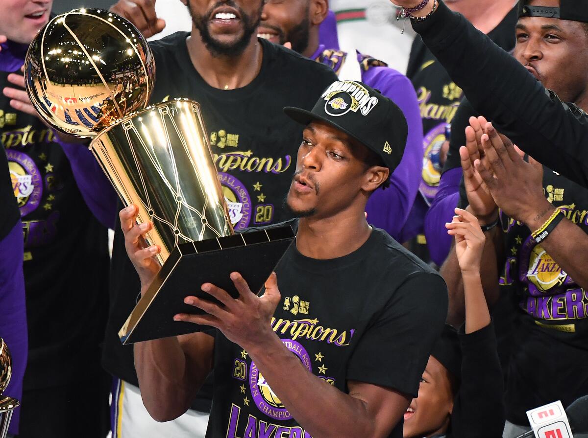 Rajon Rondo is surrounded by his teammates as he holds the trophy after the Lakers won the 2020 NBA championship.