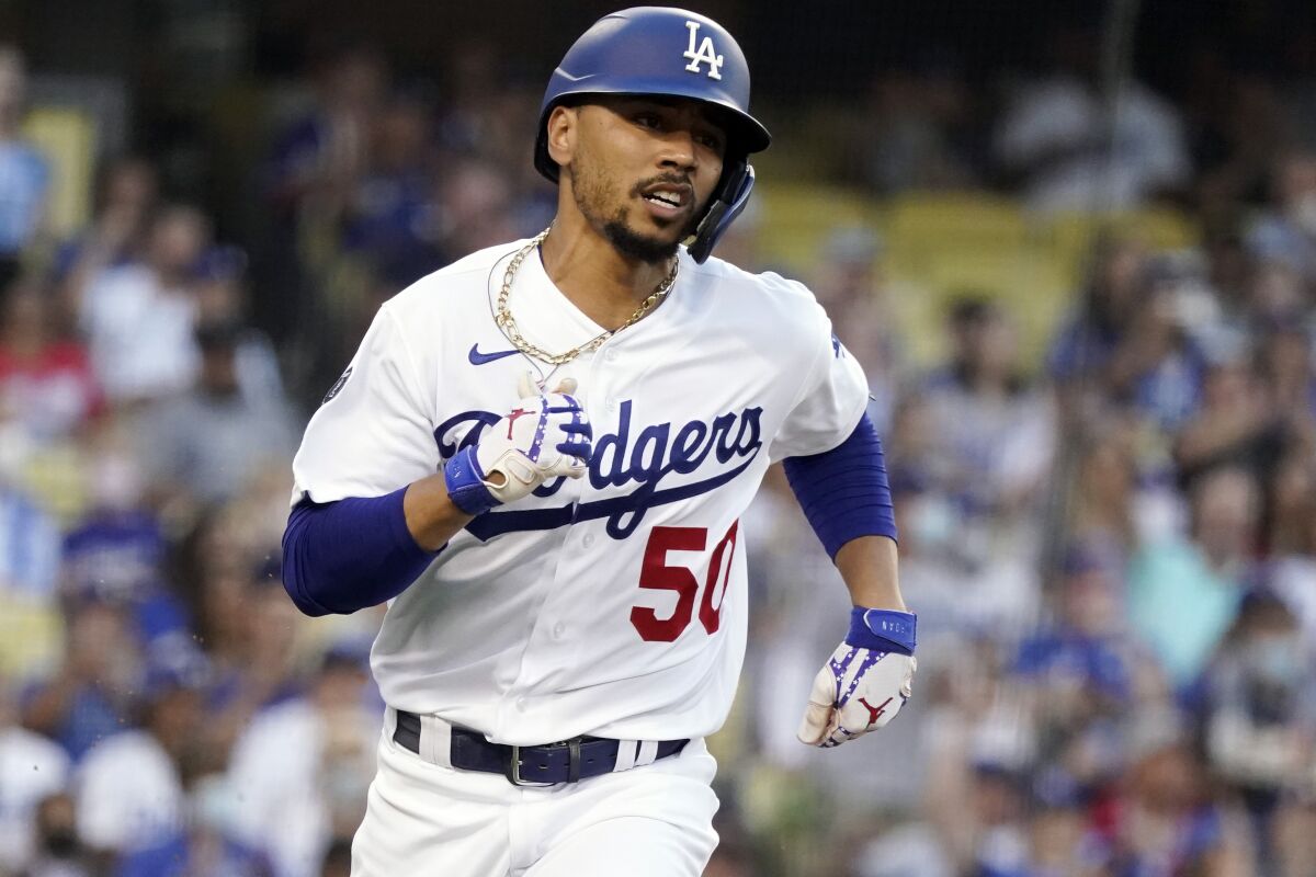 Los Angeles Dodgers' Mookie Betts runs to first on a single during the first inning of the team's baseball game against the Los Angeles Angels on Friday, Aug. 6, 2021, in Los Angeles. (AP Photo/Marcio Jose Sanchez)